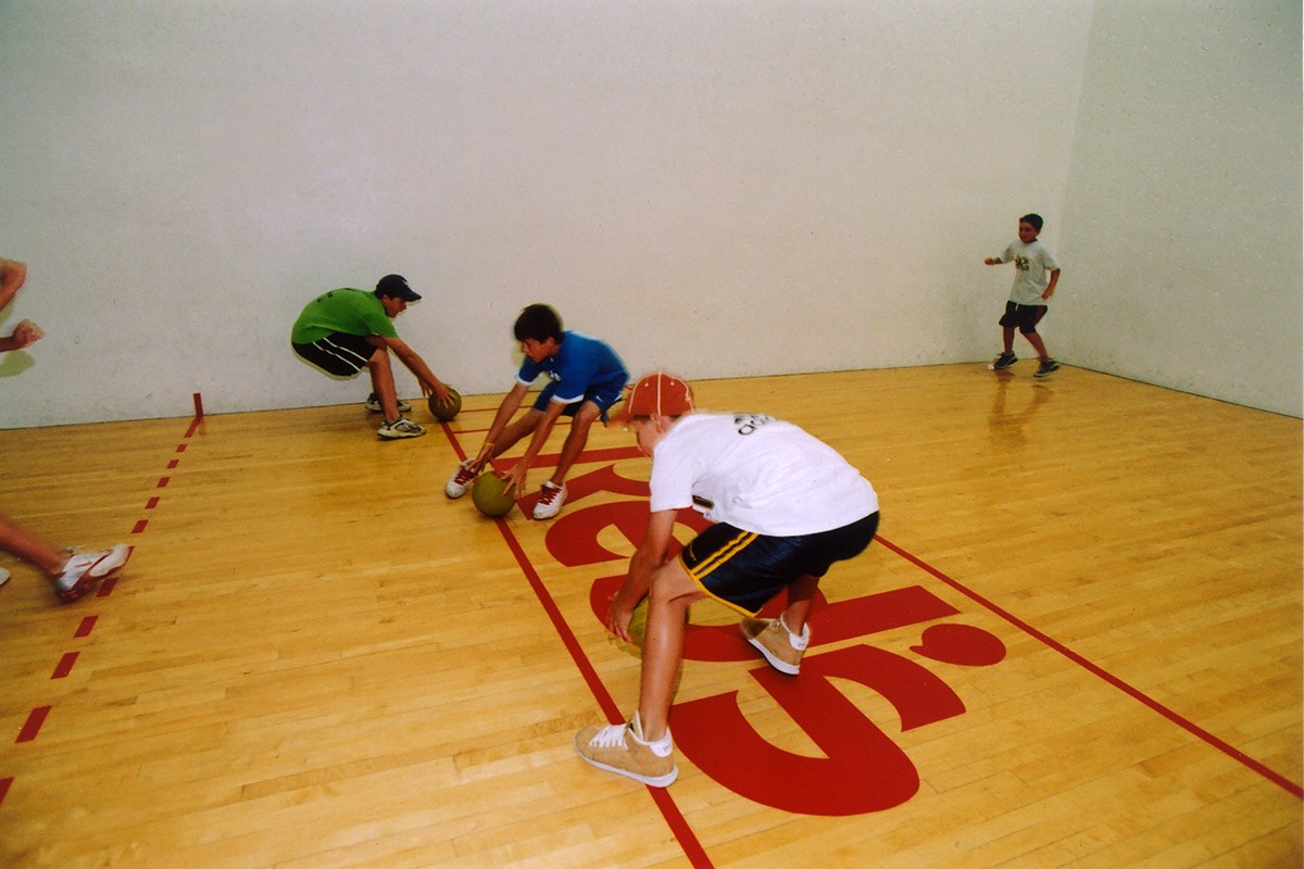 Boys playing dodgeball in racquetball court at Red's in Lafayette, LA.
