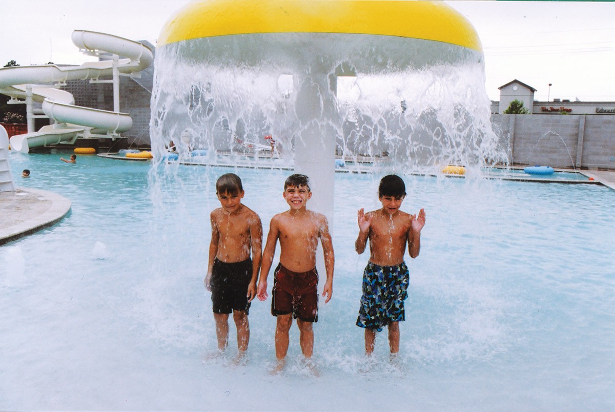 Boys under mushroom fountain in kids pool at Red's in Lafayette, LA.
