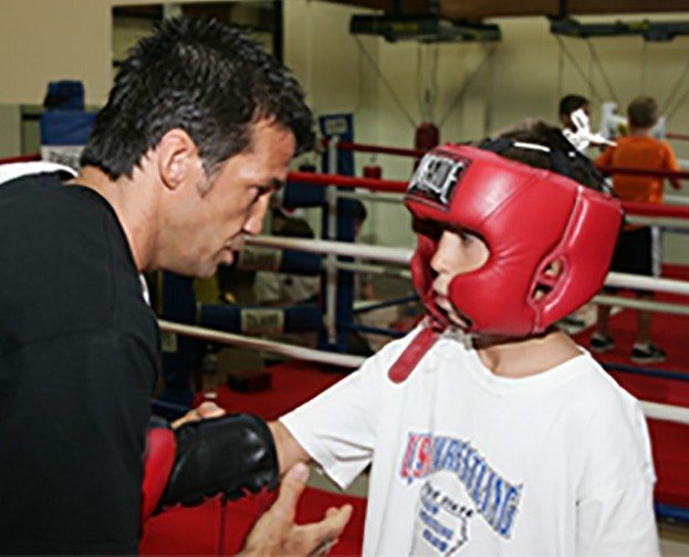 Chad Broussard, boxing personal trainer, coaching young boy in boxing ring at Red's in Lafayette, LA.