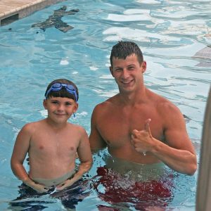 Zach, swim lesson instructor, teaching swim lesson to boy at Red's in Lafayette, LA.